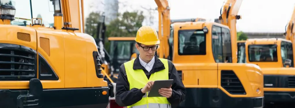 a maintenance manager using a heavy equipment management software on a tablet