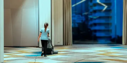 a hotel staff vacuuming the floor as part of her tasks outlined in hotel maintenance software