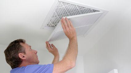an IAQ inspector checking HVAC filters during an IAQ assessment as a task listed on an indoor air quality assessment checklist|Indoor Air Quality Assessment Checklist Sample Report|Indoor Air Quality Assessment Checklist