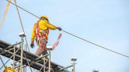 Construction professional workers wear safety harnesses and safety