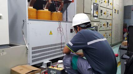 An employee performing transformer maintenance