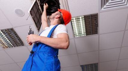 worker inspecting a ventilation system