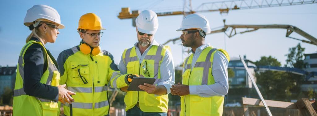 travailleurs collaboratifs sur un chantier utilisant un logiciel de construction avec une tablette