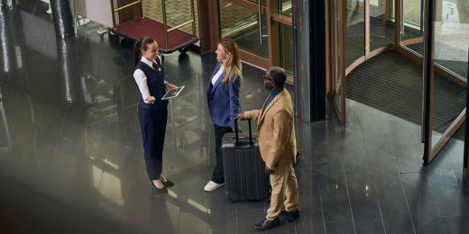 a manager welcoming guests at a hotel as part of items being checked in an LQA standards checklist