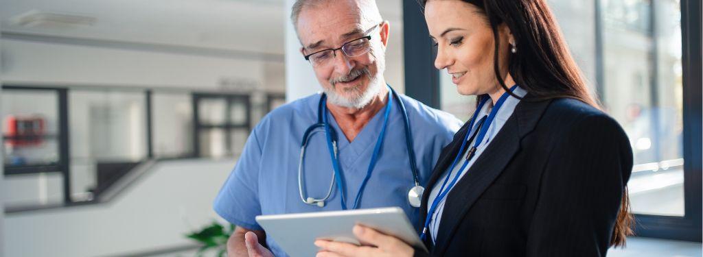 two healthcare professionals using care management software on a tablet