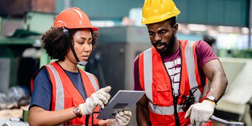 two safety professionals conducting a planned task observation in a manufacturing facility using a tablet device