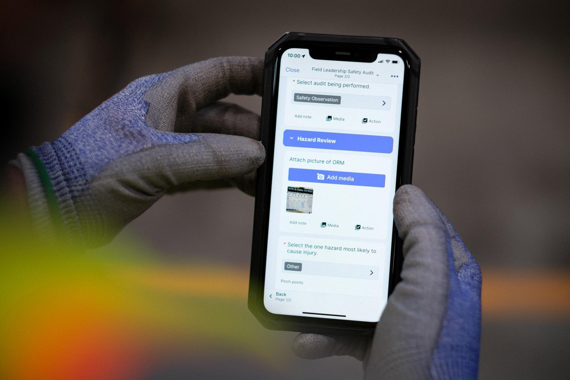 An inspector doing a safety observation using a technology to monitor workplace conditions