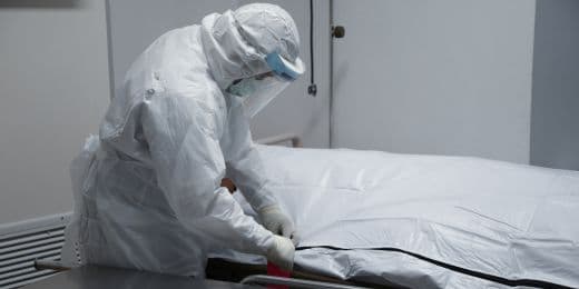 mortuary worker user embalming ppe while caring for a body