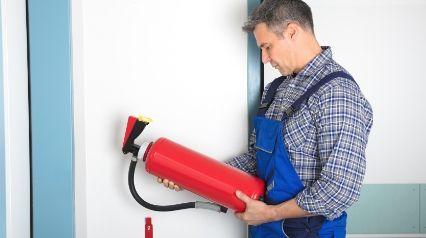 inspector que realiza la inspección de extintores|profesional inspeccionando el extintor||Lista de comprobación mensual de la inspección de extintores