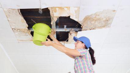 a woman checking a damaged ceiling based on the guidelines specified in a water damage restoration checklist|Water Damage Restoration Checklist Sample Report|Water Damage Restoration Checklist