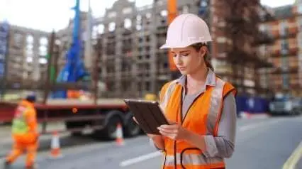 director de seguridad en la construcción utilizando una tableta en la obra
