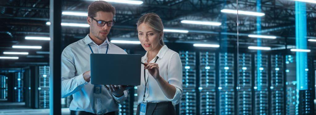 two workers using a data center monitoring software for their data hub|Datadog|Nlyte|ManageEngine OpManager|CloudMonix|EcoStruxure|Uila|Sunbird DCIM|Kaseya VSA