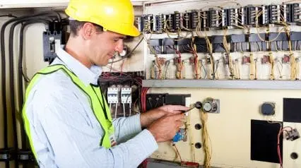 an electrician working safely with complete electrical PPE