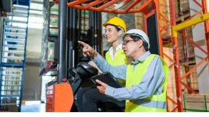 a certified forklift trainer training a worker on safely operating a forklift in a warehouse|Forklift Training Checklist|Forklift Training Checklist Sample Report
