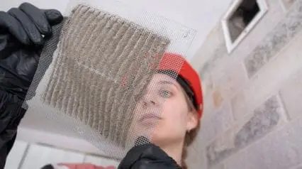 cleaner examining a vent filter to improve indoor air quality