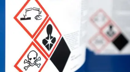 a chemical bottle with lab safety symbols attached on it