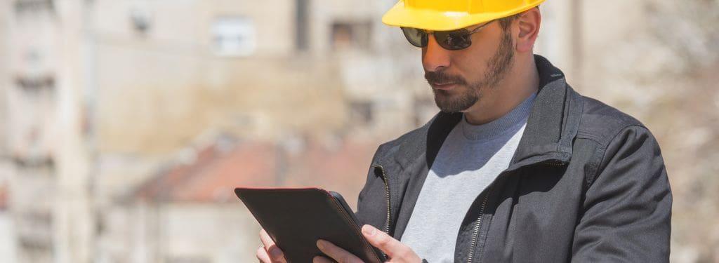 a construction manager using a punch list software on a tablet|Bluebeam Revu Punch List Software|Fieldwire Punch List Software|PlanGrid Punch List Software|Procore Punch List Software|Raken Punch List Software|Traqspera Punch List Software