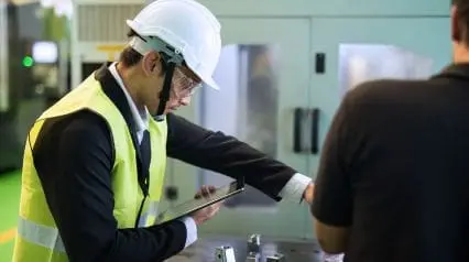 a manufacturing engineer conducting quality assurance checks using a tablet