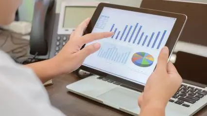 an operations manager using a tablet to monitor operations analytics through operational excellence examples