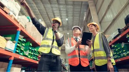 workers in a warehouse conducting an inventory audit with a checklist in their tablet