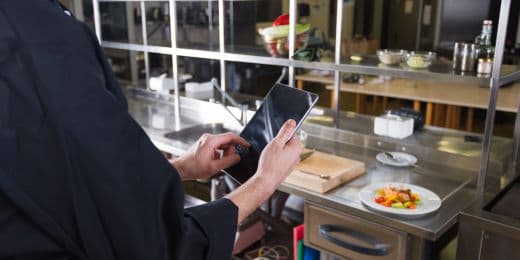 Chef using a tablet to monitor restaurant temperature readings