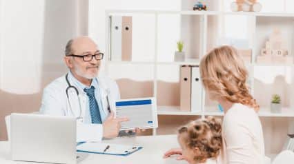 doctor using a digital tool to document child observations