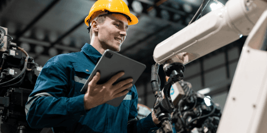 A mechanic inspecting production line equipment with a tablet.