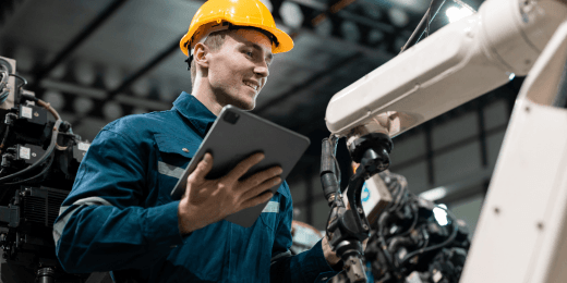 A mechanic inspecting production line equipment with a tablet.