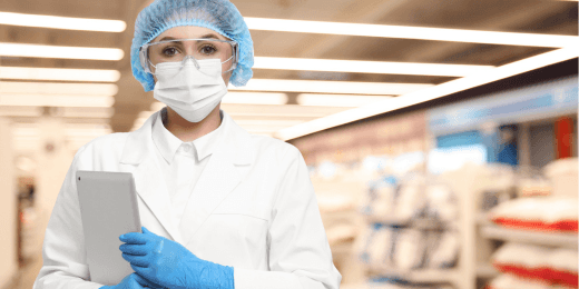 Masked woman holding a tablet and wearing PPE