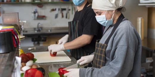 Workers in a hotel kitchen following HACCP plans for food prepartion
