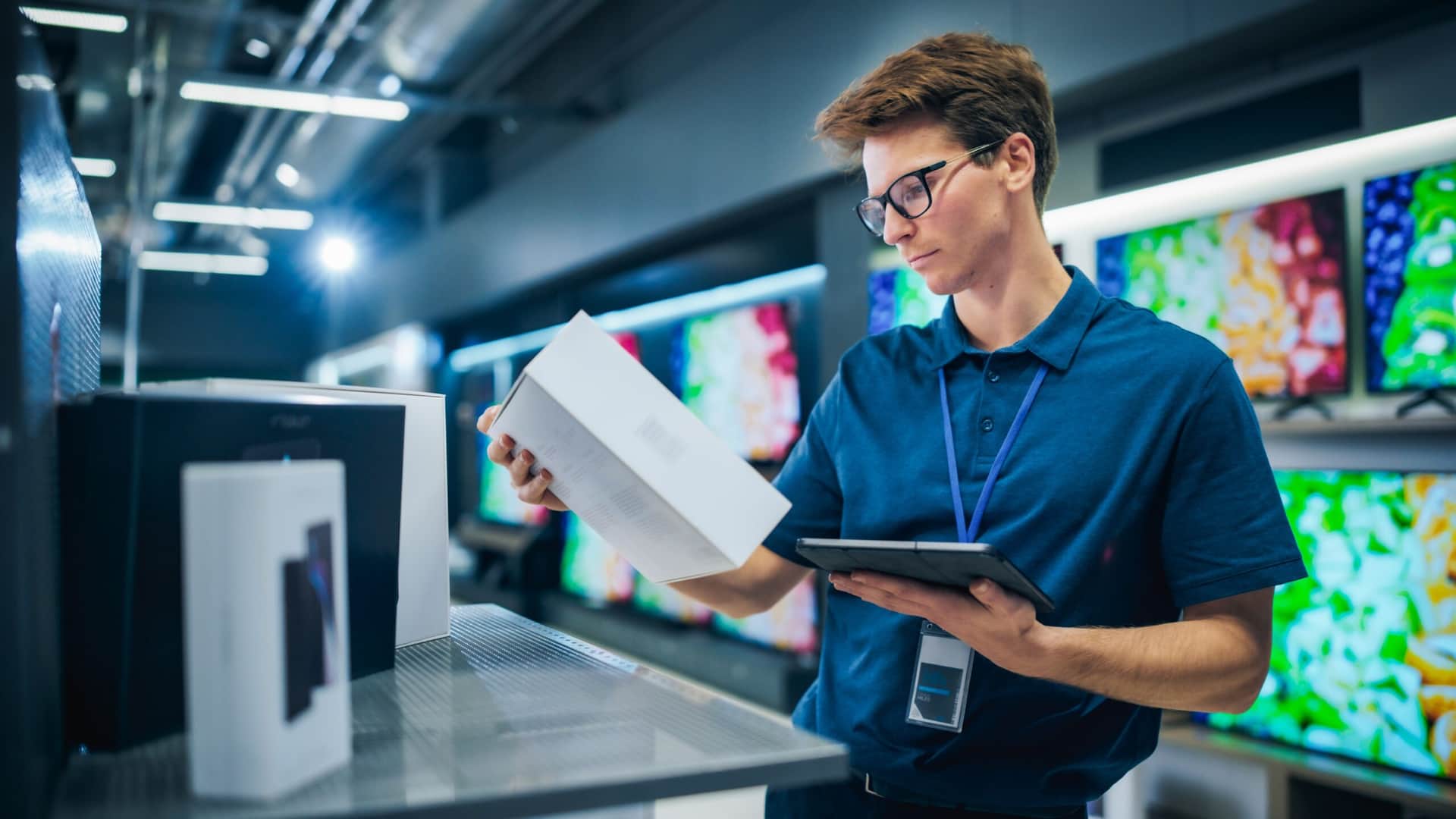 A male shopkeeper doing checks using retail store management software
