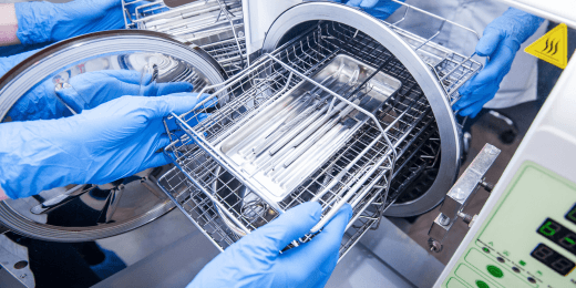 A nurse using steam sterilization on medical devices.