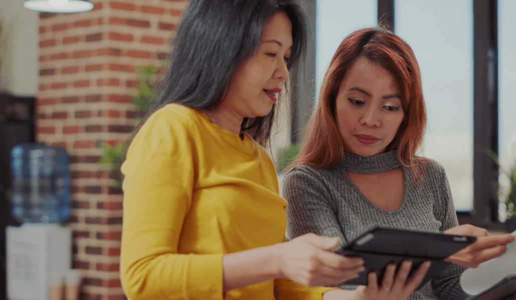 Two colleagues reviewing a risk assessment on a tablet in an office setting.
