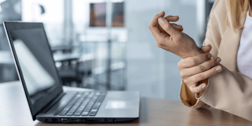 Office worker holding her wrist in pain from repetitive motion