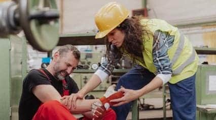 woman providing first aid to injured coworker