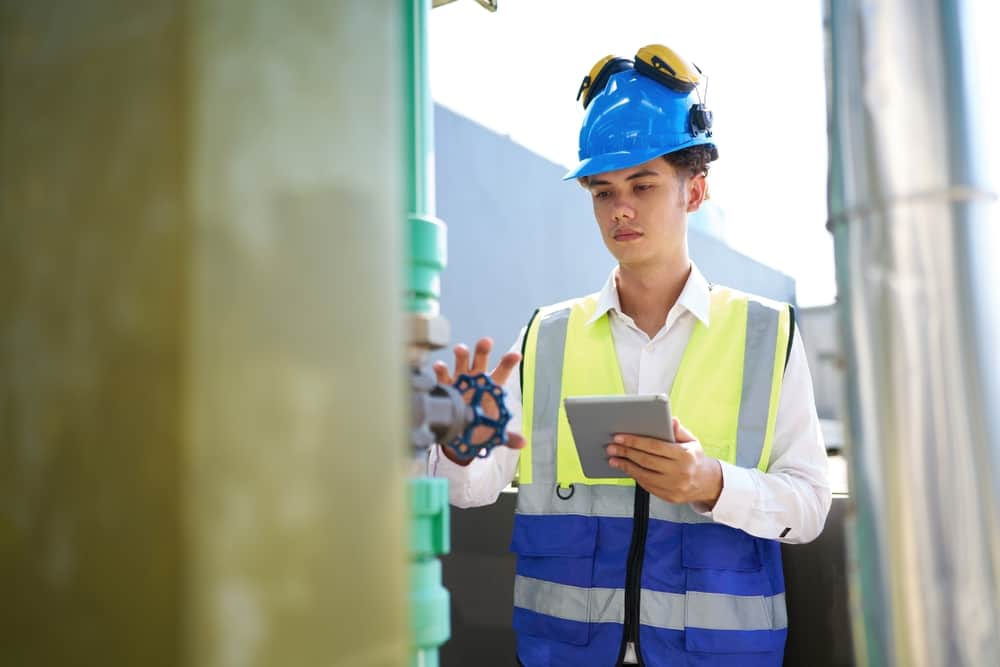 A construction consultant performing an extreme heat preparedness plan checkup with his phone.