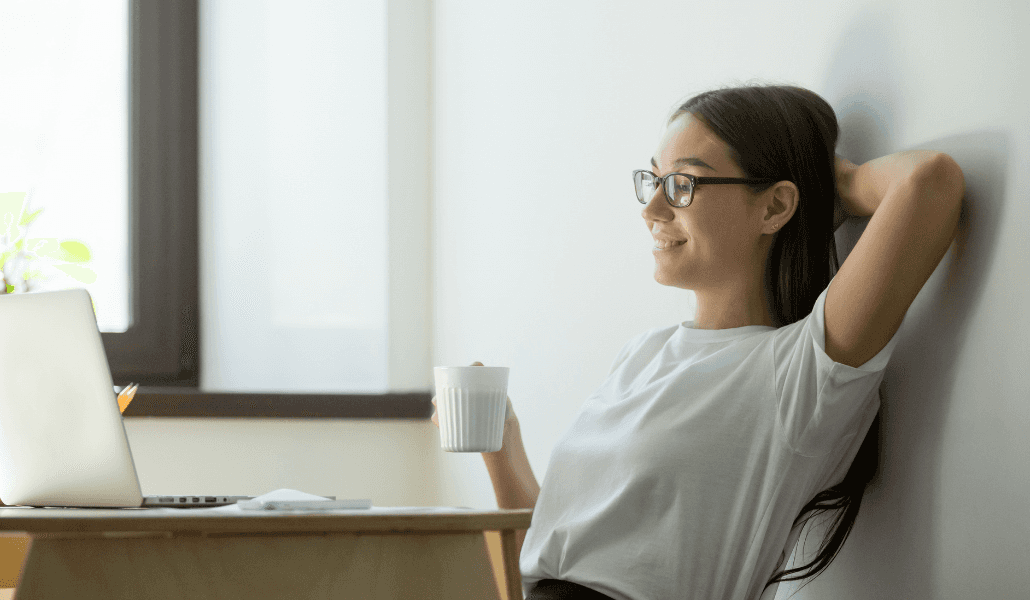 A woman enjoying a cup of coffee during work.