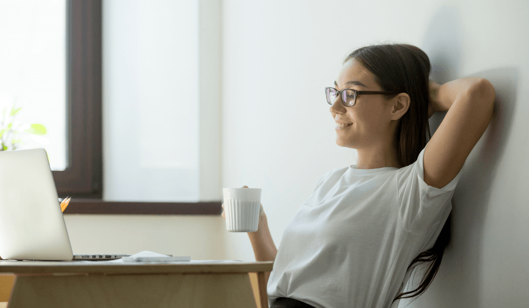 A woman enjoying a cup of coffee during work.