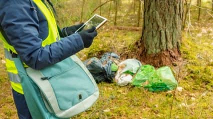 an auditor using an environmental audit checklist on a tablet|Environmental Audit Checklist Sample Report|Lista de comprobación de la auditoría medioambiental