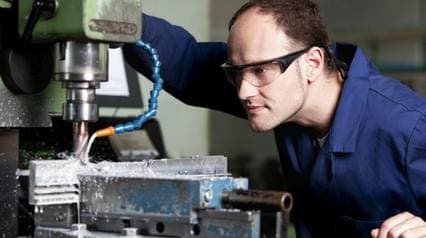 metalworker processes metal with an angle grinder