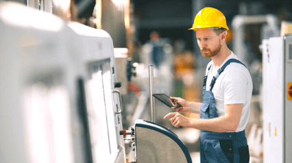 trabajador de lean manufacturing aplicando el principio de jidoka usando una tableta