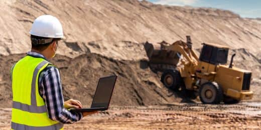 worker reading a mine safety training guide on their laptop while on site