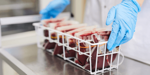A doctor handling a basket filled with blood bags in a medical facility.