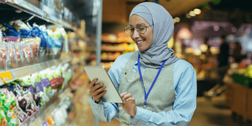 Hijabi woman holding an ipad in front of a retail display
