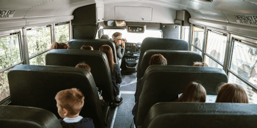 A school bus with children sitting inside.