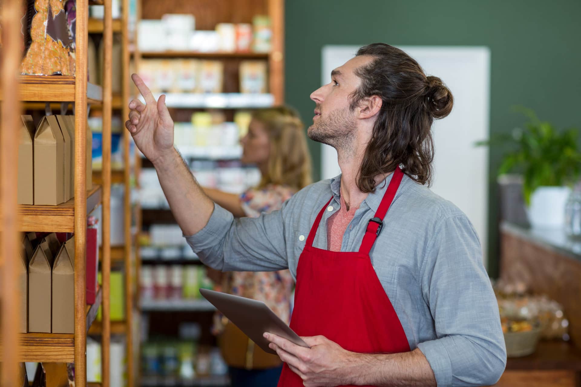 A male shopkeeper performing checks using retail facility management software