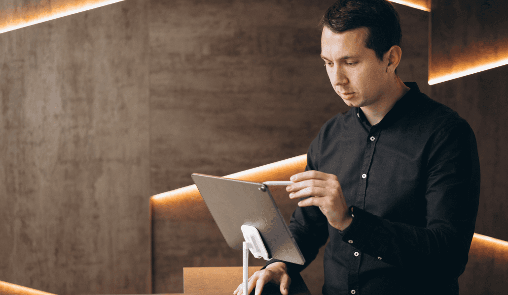 Hotel staff member using a tablet to check up on guest reservations.