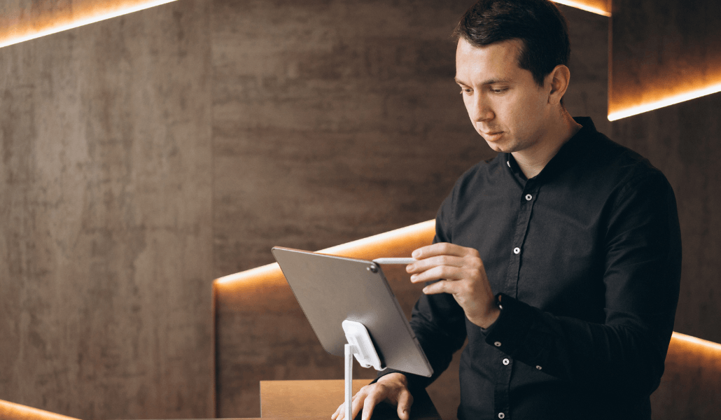 Hotel staff member using a tablet to check up on guest reservations.