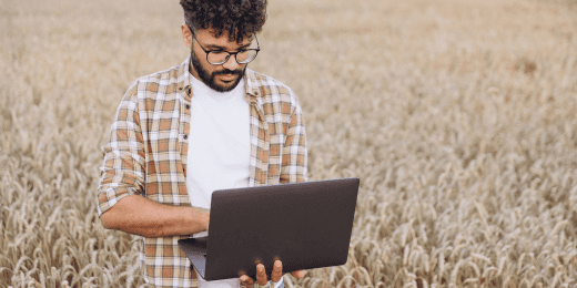 Man working on his laptop in an agricultural field