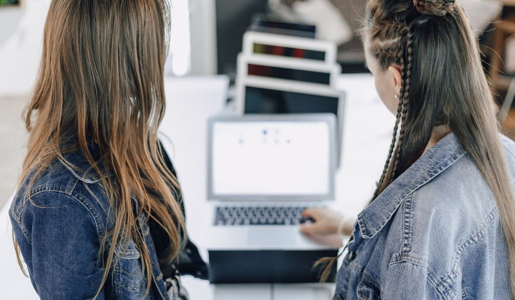 Retail workers in the back of a retail store using different laptops for work